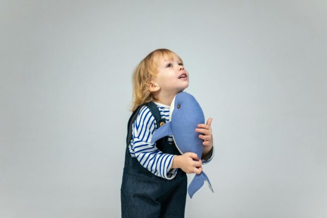 girl in blue and white striped long sleeve shirt holding blue balloon